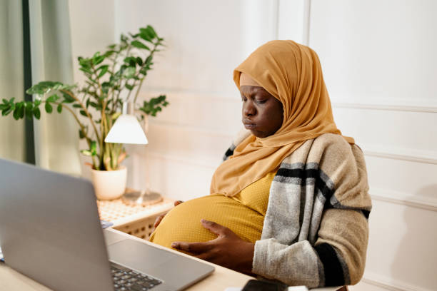 istock Pregnant  black muslim woman working from office 1455010253