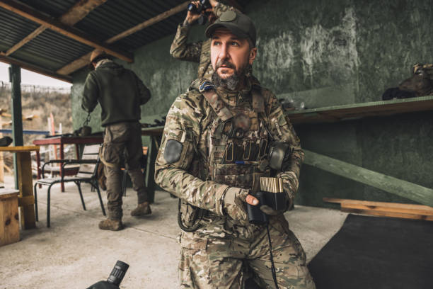 istock Serious soldier in camouflage with an optical rifle 1455010603