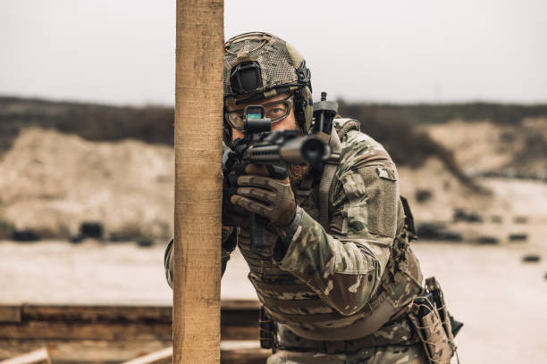 istock Bearded sniper with optical rifle shooting 1455010652