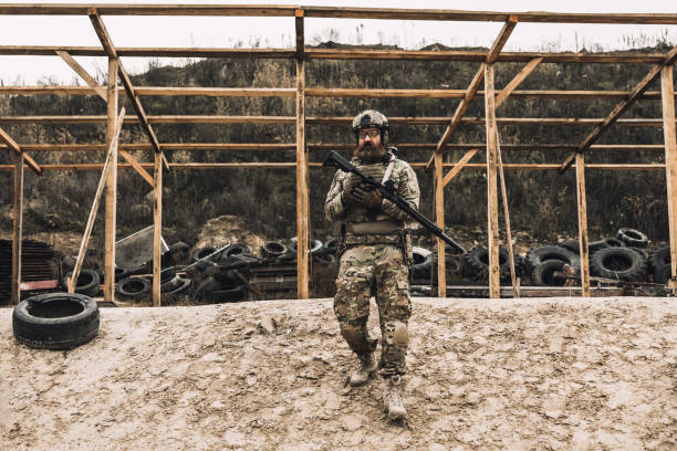 istock Soldier in camouflage with a rifle in hands 1455010669