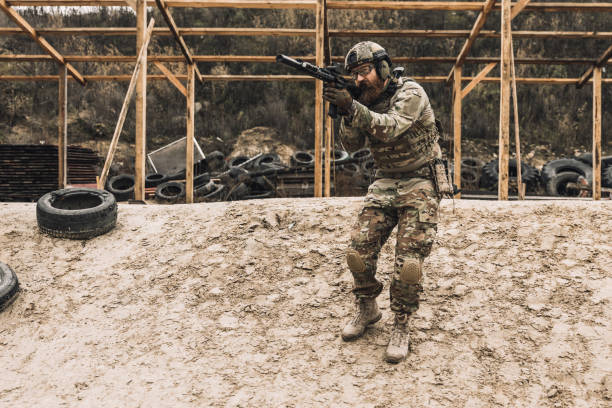 istock Soldier in camouflage with a rifle in hands 1455010675