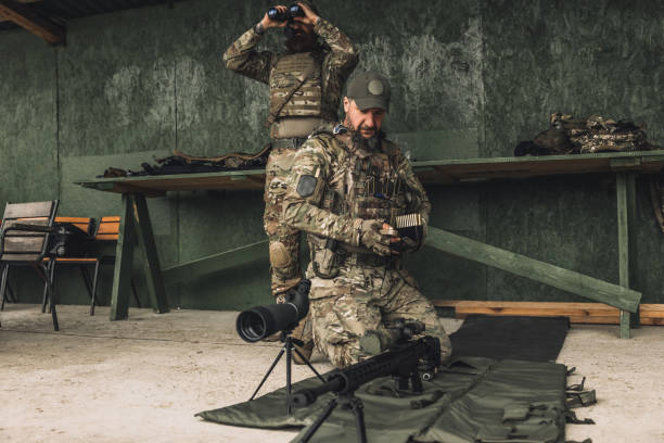istock Serious soldier in camouflage with an optical rifle 1455010830