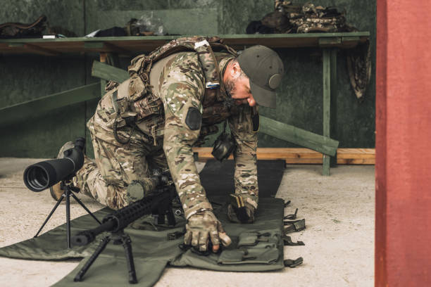 istock Serious soldier in camouflage with an optical rifle 1455010833