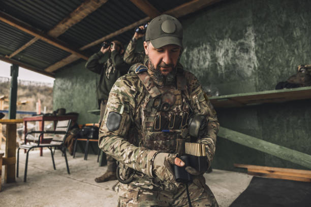 istock Serious soldier in camouflage with an optical rifle 1455010843