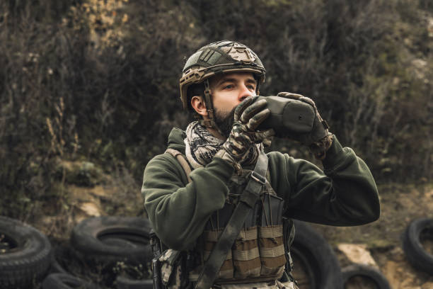 istock Soldier in military uniform drinking from flask 1455010956