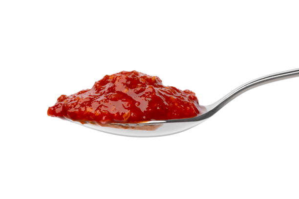 istock Metal spoon with red sambal, Indonesian chilli sauce, on white background 1455011041