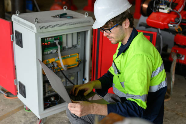 istock Professional male technician worker in white helmet checking machine maintenance on laptop at factory 1455012594