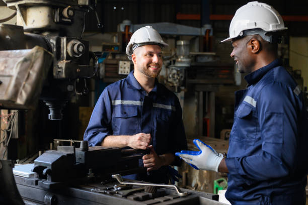 istock Two industrial engineers team with safety uniform talking and working together at manufacturing factory 1455012807