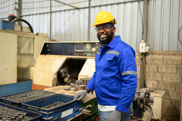 retrato do trabalhador de engenharia do sexo masculino confiante sorrindo e trabalhando na fábrica - african descent factory accuracy analyzing - fotografias e filmes do acervo