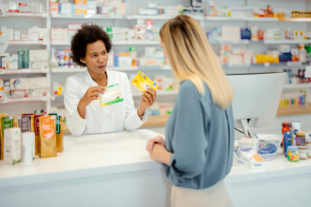 istock Female Pharmacist Giving Prescription 1455017982