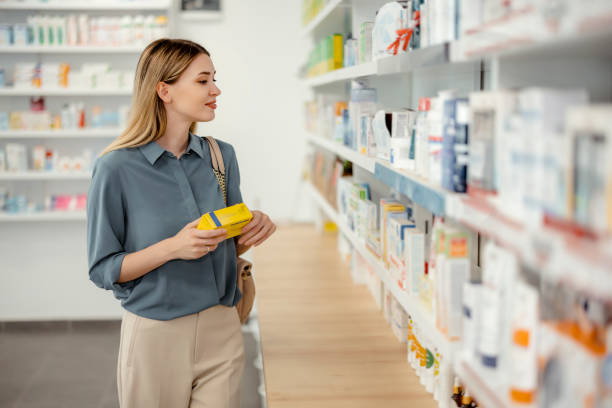 약국에서 약을 쇼핑하는 여자 - 약국 뉴스 사진 이미지