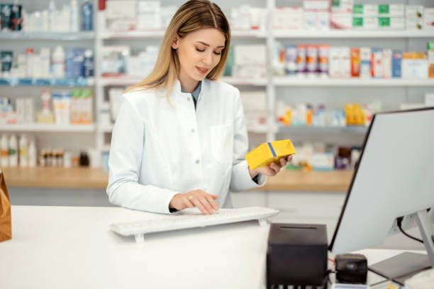 farmaceutka korzystająca z komputera kasowego - checkout counter pharmacy pharmacist patient zdjęcia i obrazy z banku zdjęć