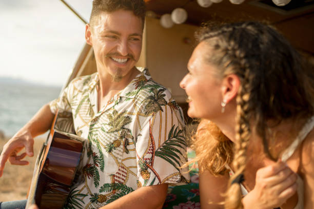 istock Man playing the guitar next to a woman in a van 1455018839