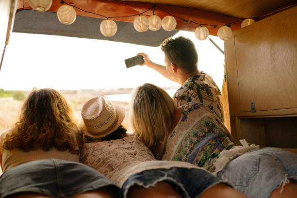 istock Rear view of friends taking selfie inside a camper van 1455018922