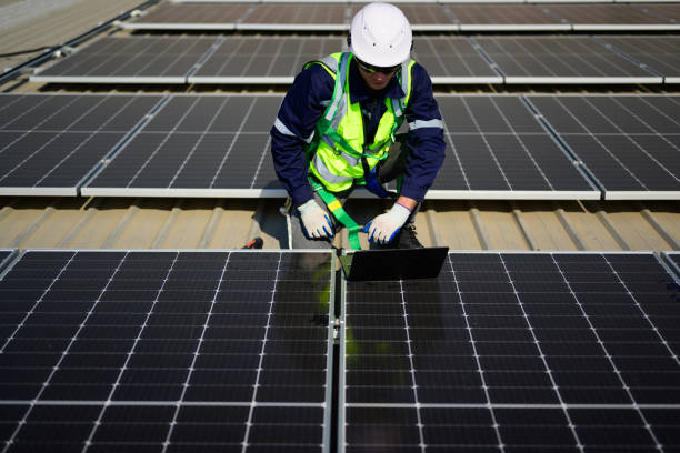 istock Engineer technician using laptop checking and operating system on rooftop of solar cell farm power plant, Renewable energy source for electricity and power, Solar cell maintenance concept 1455018960