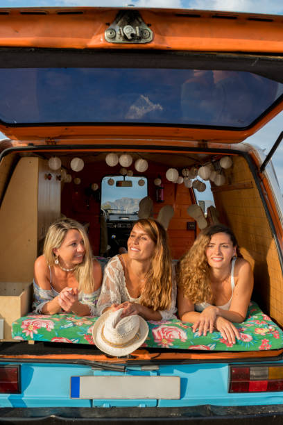 istock Three women lying inside a van parked on the beach during sunset 1455019023