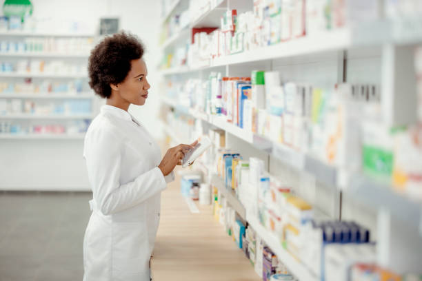istock Female Pharmacist Using Tablet-pc in the Pharmacy 1455019080