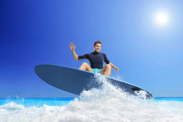 istock Young man riding a surfboard in the sea 1455022361