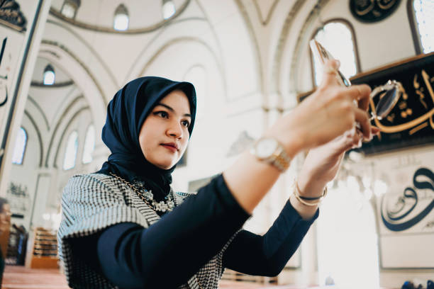 istock young muslim woman using mobile phone in the mosque 1455022673