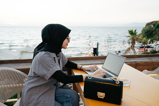 asian muslim woman working during holiday  in the tourist resort