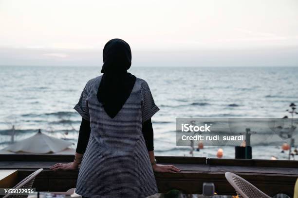 Muslim Woman Looking The Beach From The Deck Stock Photo - Download Image Now - One Woman Only, Women, Rear View