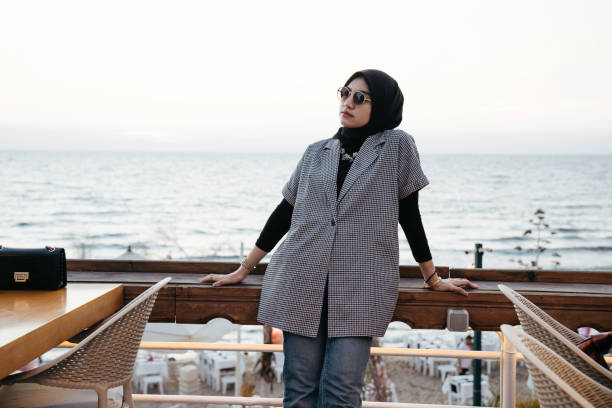 istock muslim woman looking the beach from the deck 1455022964