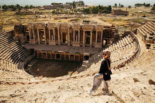 Female Tourist in the Ancient Roman Amphitheater Ruin the The Holy City of Hierapolis next to the Pamukkale hot springs in Western Turkey built in the 2nd Century and is now a UNESCO World Heritage Stie