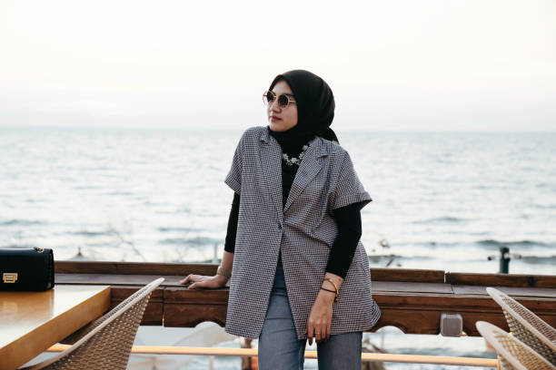 istock muslim woman looking the beach from the deck 1455023149