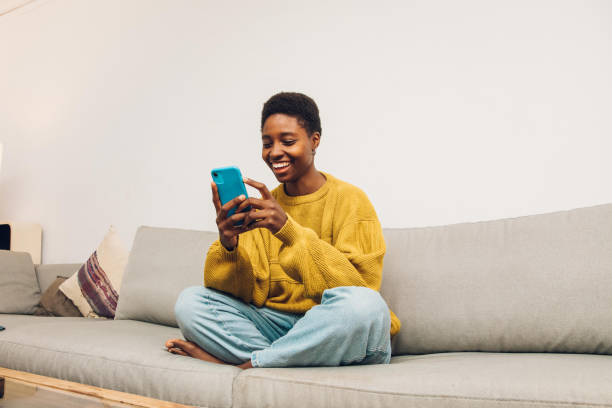 istock African woman using cellphone at home 1455025265