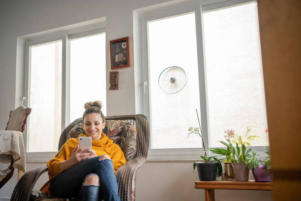 istock Woman using cell phone at home 1455027261