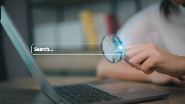 istock Woman use magnifying glass Search On Virtual Screen Data Search Technology Search Engine Optimization. Woman use computer to Searching for information. Using Search Console for data, info. 1455031234