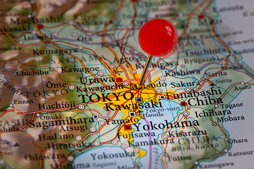 A push pin on a map of marking the location of the Japanese capital city of Tokyo on the Island of Honshu with copy space