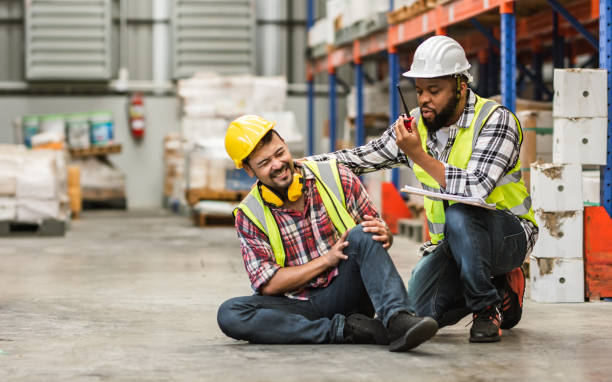 istock Professional male worker help his colleague after getting accident, injured leg while working in factory or warehouse. Safety, Industry, Healthcare, Insurance Concept. 1455039057