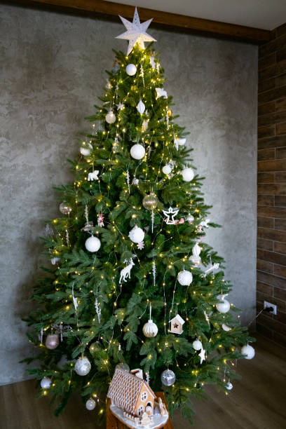 istock Beautiful Christmas tree with a star and a gingerbread house underneath. 1455040047