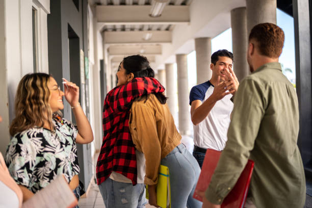 istock Young friends greeting each other at university 1455042673