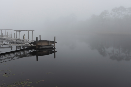 Canoe launch pier and lagoon covered by dense fog