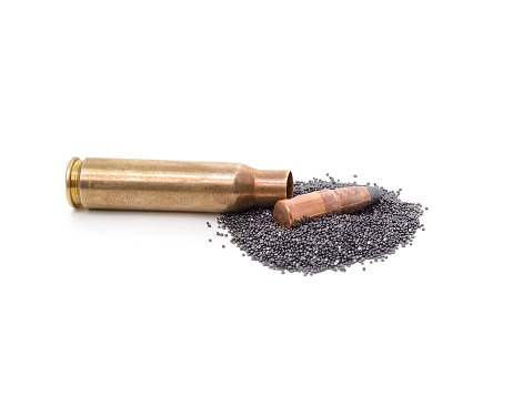 Cartridge case and a pile of gunpowder isolated on a white background.