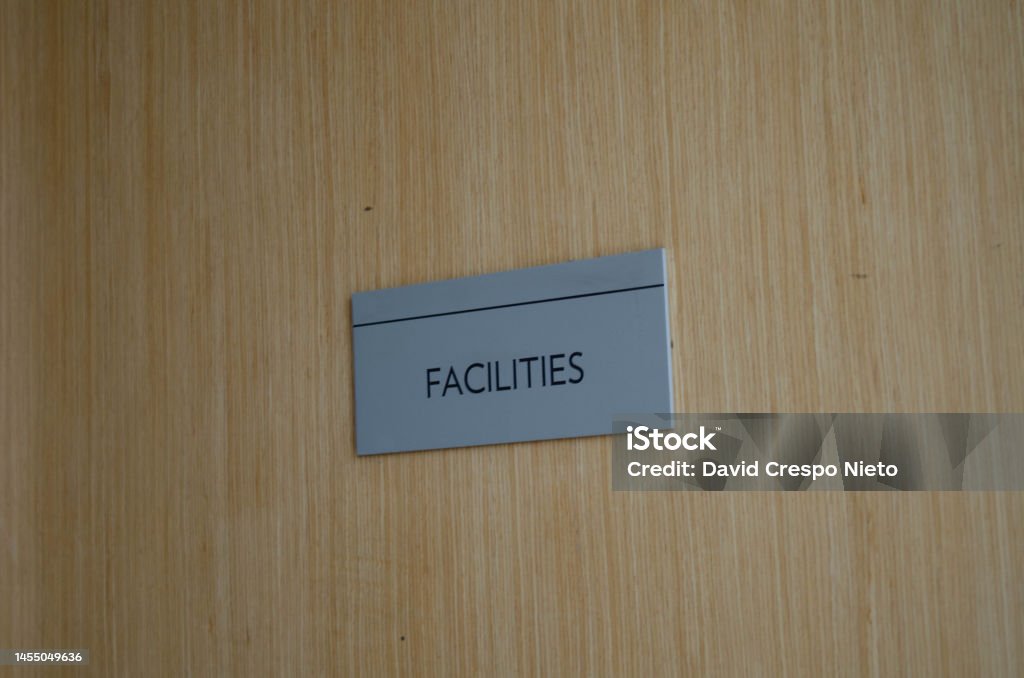 Facilities sign Sign in a door indicating the the facilities area is behind it. Color Image Stock Photo