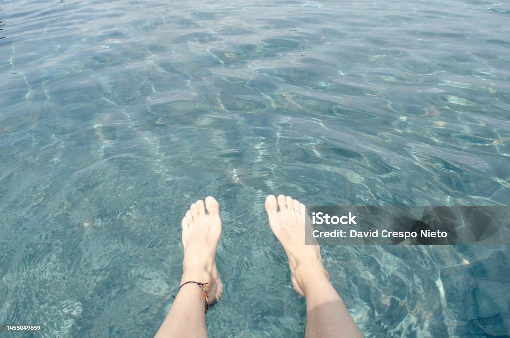 Feet on a pool Feet of one person with a swimming pool on the background. Adult Stock Photo