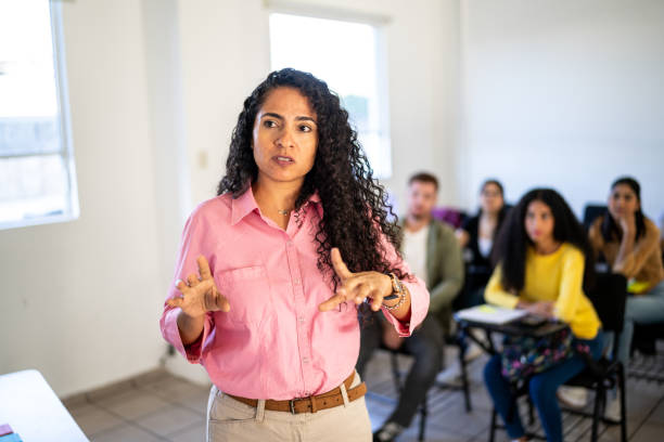 istock Mid adult teacher explaining lesson to university students in the classroom at university 1455051380