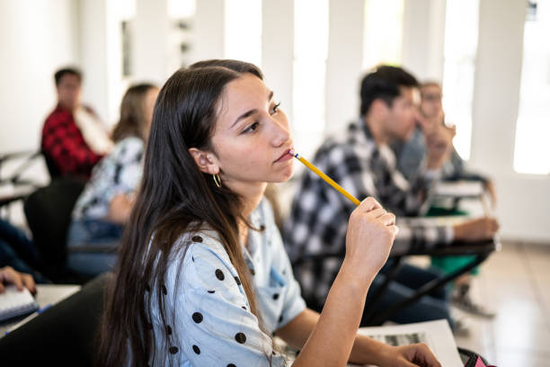 istock Young woman thinking while watch class at university 1455052653