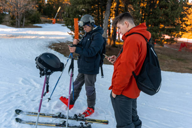 two boys in ski clothes looking at the phone - apres ski winter friendship ski imagens e fotografias de stock