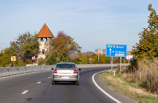 Transylvania, Romania - October 24, 2022: A picture of a car driving on a Romanian road.