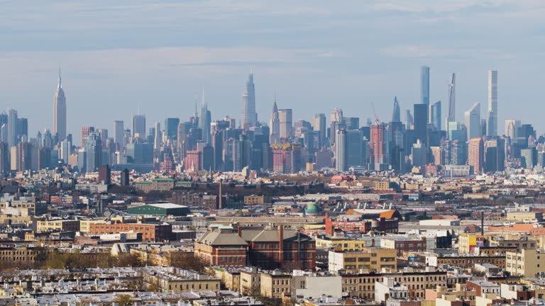 Distant aerial view on Freedom Tower in Lower Manhattan from Bushwick over the residential district in Brooklyn, New York. Drone video with the panning camera motion.