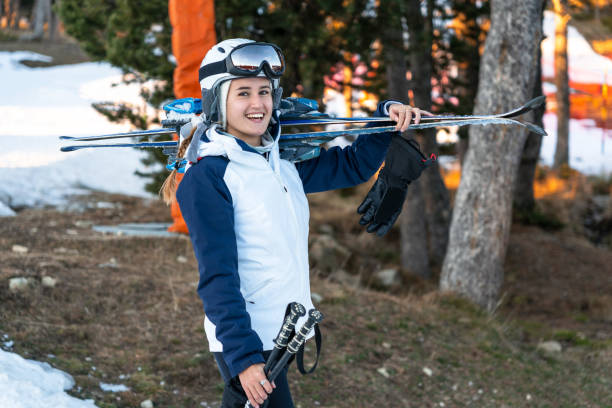 girl carrying a pair of skis on her shoulder. - ski resort winter sport apres ski ski slope imagens e fotografias de stock