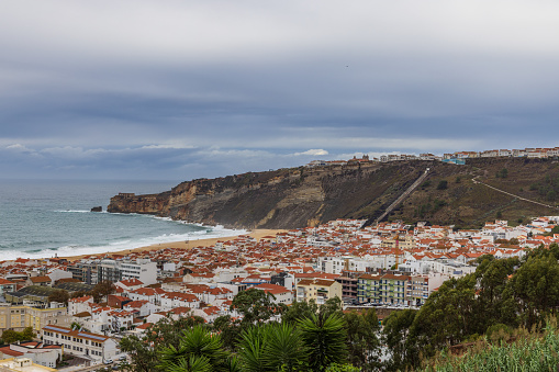 Wide view of the city of Nazaré, the beach, cliffs, funicular  and the fort of São Miguel Arcanjo