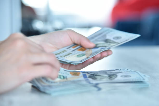 istock Trader woman hands counting usa dollars on table. 1455064120