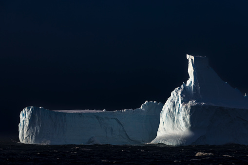 Large icebergs dot the seascape off the coast of Antarctica.