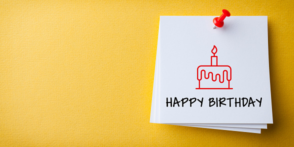 White Sticky Note With Happy Birthday And Red Push Pin On Yellow Background