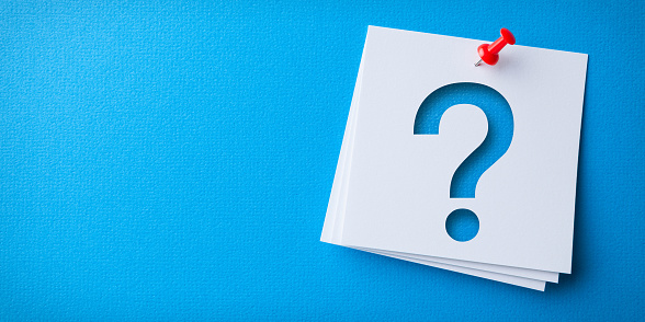 White Sticky Note With Question Mark And Red Push Pin On Blue Cardboard